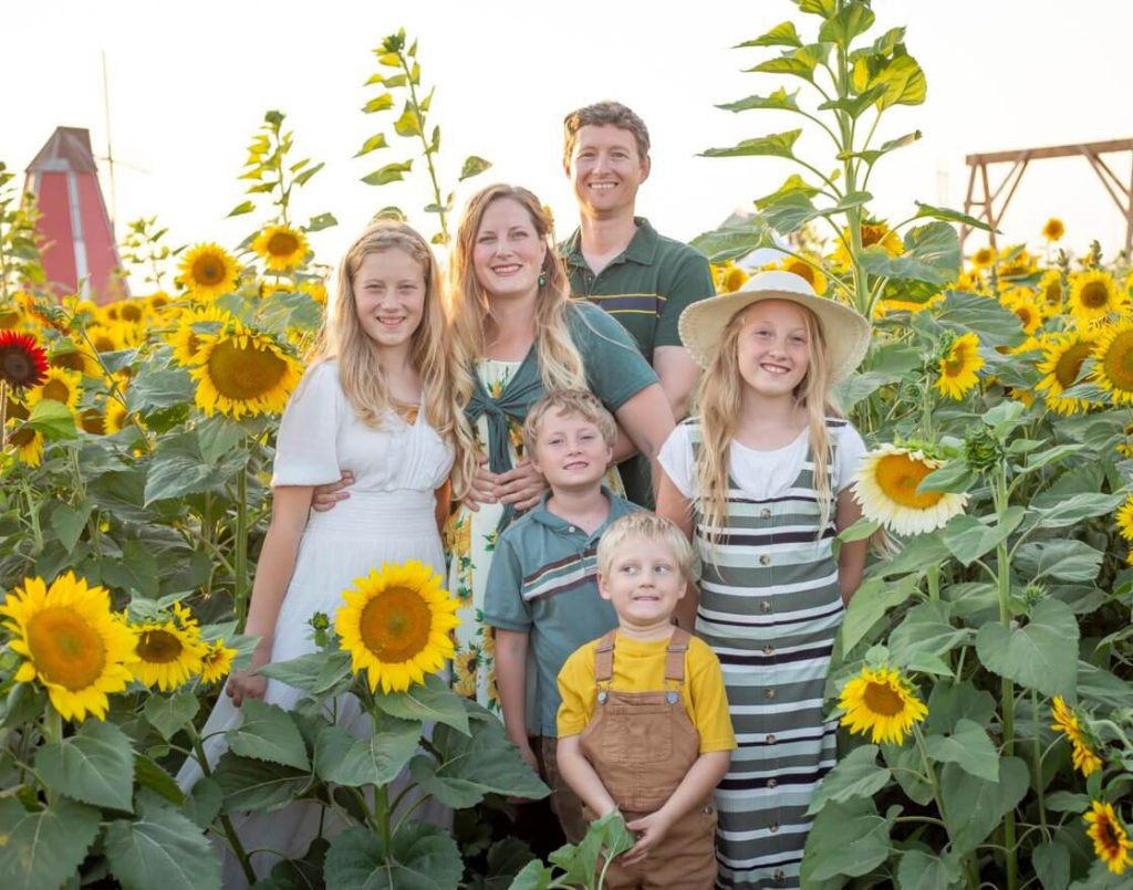 Sheri and her family posing in a sunflower patch