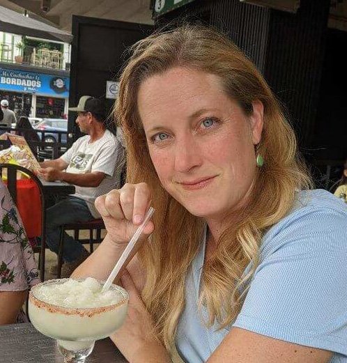 Sheri smiling casually with a drink