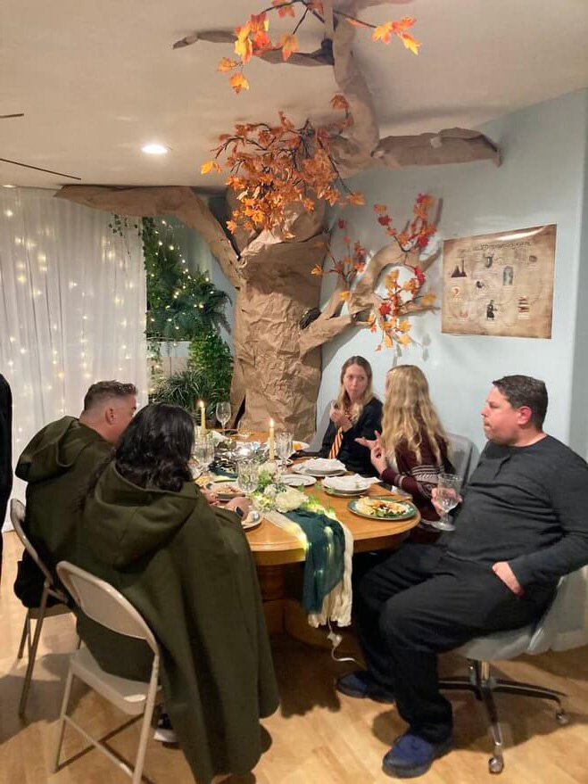 Social event with woodsy decorations and people dressed in costume